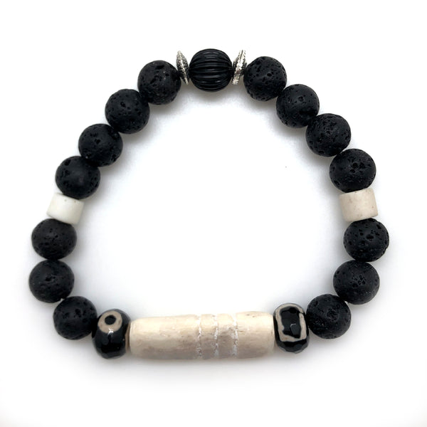 The Boner Bracelet boasts a broad handcrafted bone feature and to delicate Bone spacers midway around the circumference. The feature is accented with adjacent rondelles of black and white glass faceted to add a bit of sparkle.