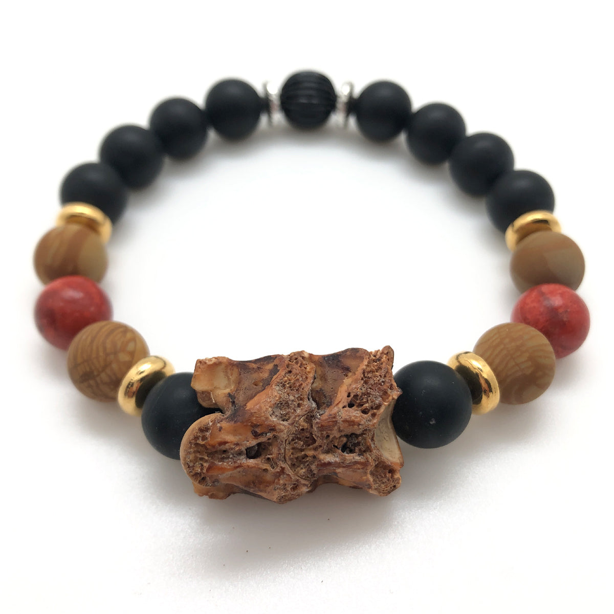 The Serpent Bracelet features two natural brown eel vertebrae, warm Wood Jasper and Orange Spongy beads, Gold plated brass rondelles. Matte Black Onyx.
