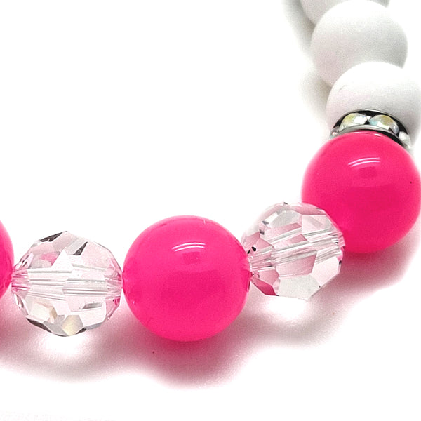 The Trixie Bracelet features Pink Resin Beads from Germany, Swavorski® Clear Round Crystals and Rondelles in Rhodium, and Matte White Agate.